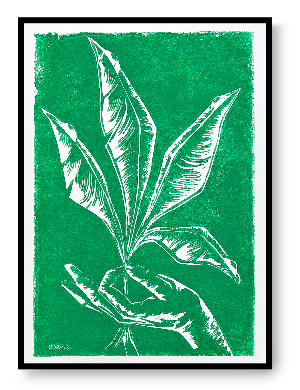 Handmade green botanical linocut print titled Vers by Belgian artist Leda Vaes featuring abstract tropical leaves and a hand in bold carved lines on textured paper, contemporary nature-inspired wall art in A3 format.