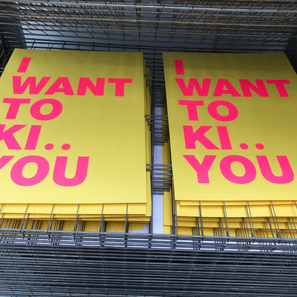 Large handmade screenprint with bold pink and yellow text reading "I want to ki.. you" — playful, humorous poster by Dutch studio Gumbootz, ideal for modern interiors and statement walls.